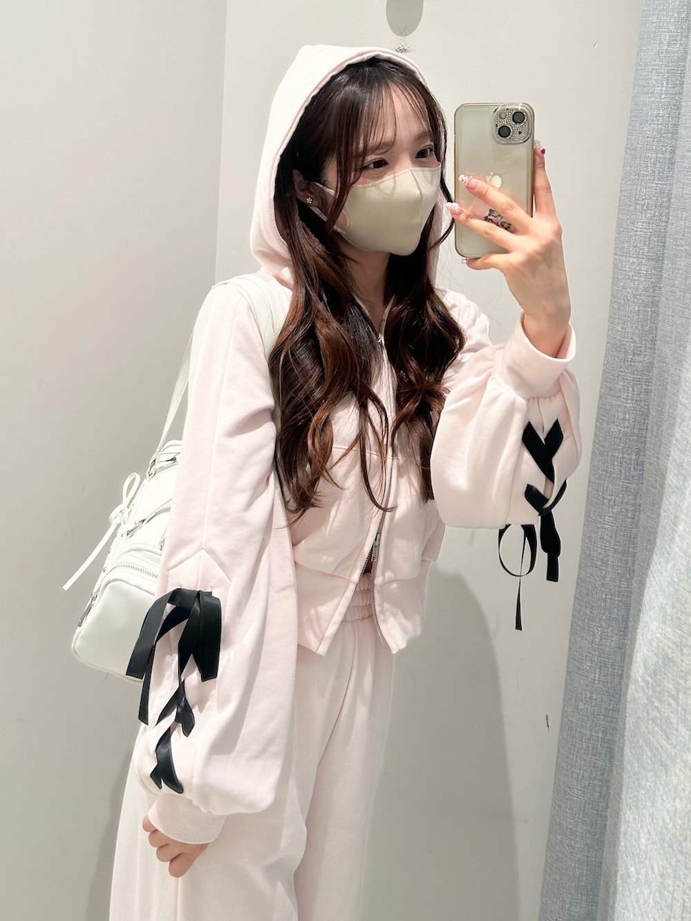 ホワイト系のスニーカー、ピンク系のスウェットパンツ、ピンク系のパーカーを着用したレディースの冬コーディネートの5枚目の写真