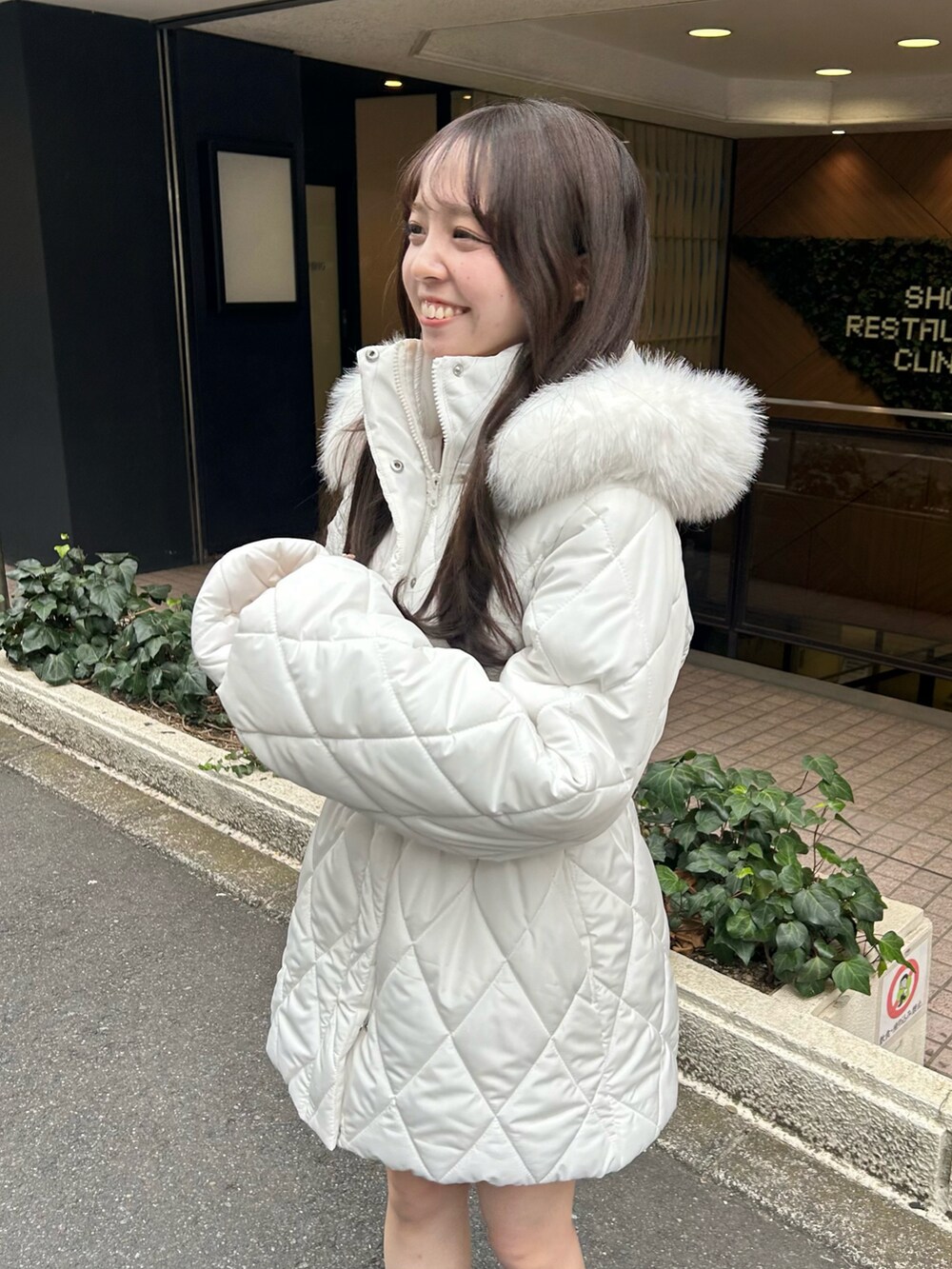 ブラック系のブーツ、ホワイト系のスカート、ホワイト系のその他アウターを着用したレディースの秋コーディネートの3枚目の写真