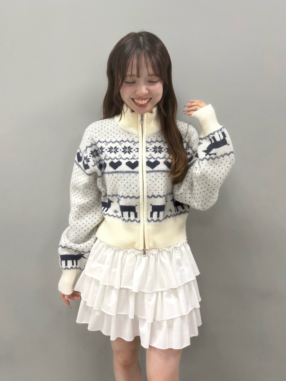 ホワイト系のニット/セーター、ホワイト系のスカート、ブラック系のブーツを着用したレディースの秋コーディネートの3枚目の写真