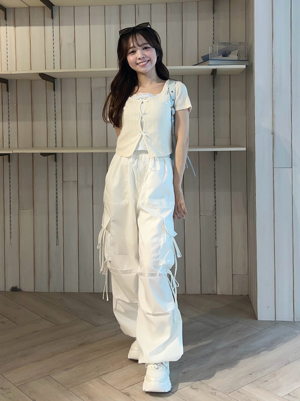 ピンク系のシューズ、ホワイト系のカーゴパンツ、ホワイト系のTシャツ/カットソーを着用したレディースの春コーディネートの2枚目の写真