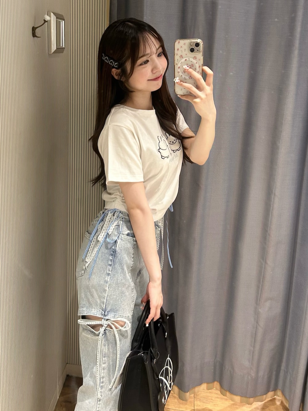 ホワイト系のTシャツ/カットソー、ブラック系のデニムパンツ、ブラック系のトートバッグを着用したレディースの春コーディネートの3枚目の写真