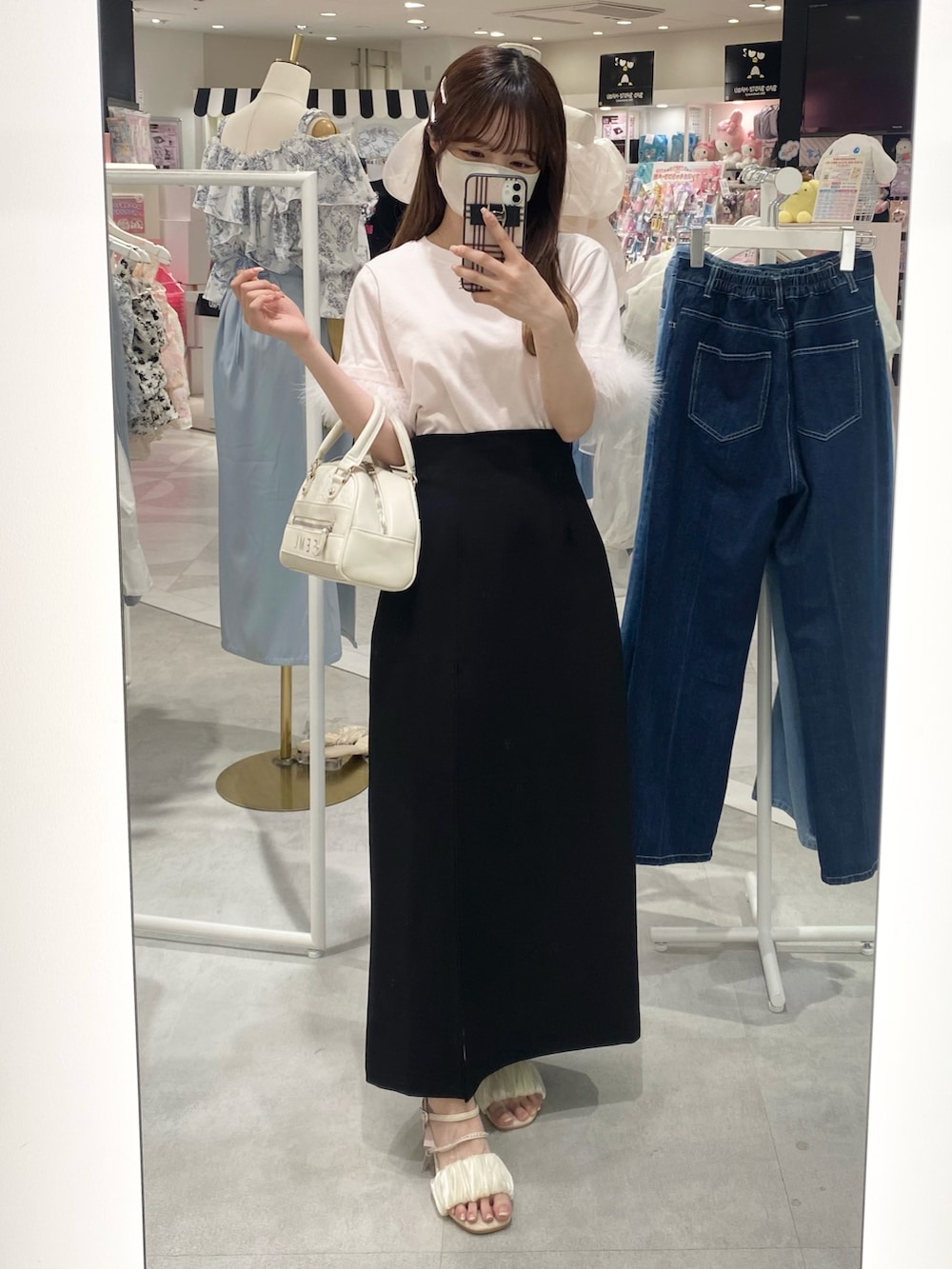 ピンク系のTシャツ/カットソー、ブラック系のスカート、ホワイト系のボストンバッグを着用したレディースの春コーディネートの2枚目の写真