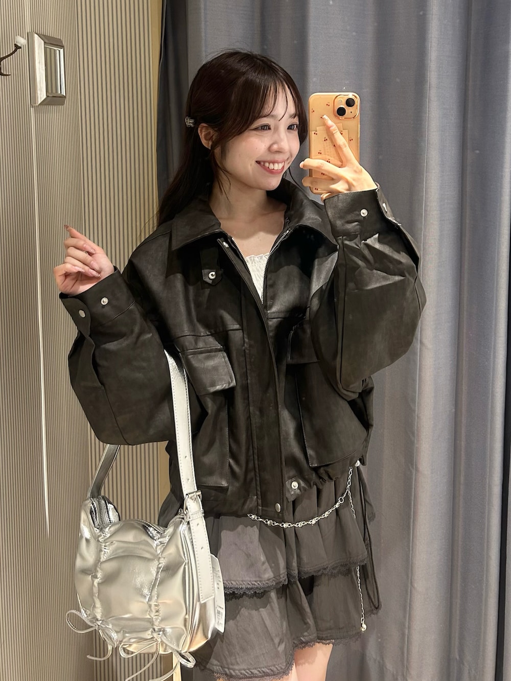 ブラック系のブルゾン、グレー系のスカート、ブラック系のブーツを着用したレディースの秋コーディネートの2枚目の写真