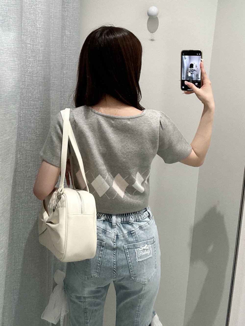 グレー系のアンサンブル、ホワイト系のスニーカー、ブルー系のデニムパンツを着用したレディースの夏コーディネートの5枚目の写真