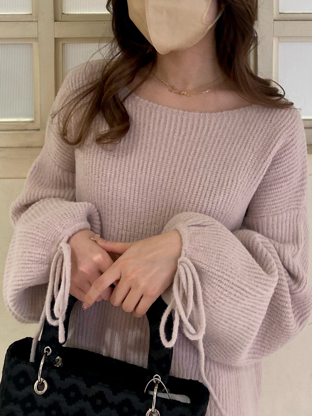 ホワイト系のブーツ、ピンク系のワンピース、ブラック系のショルダーバッグを着用したレディースの冬コーディネートの4枚目の写真