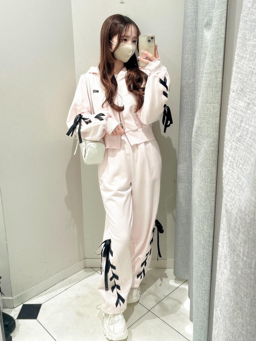 ホワイト系のスニーカー、ピンク系のスウェットパンツ、ピンク系のパーカーを着用したレディースの冬コーディネートの2枚目の写真