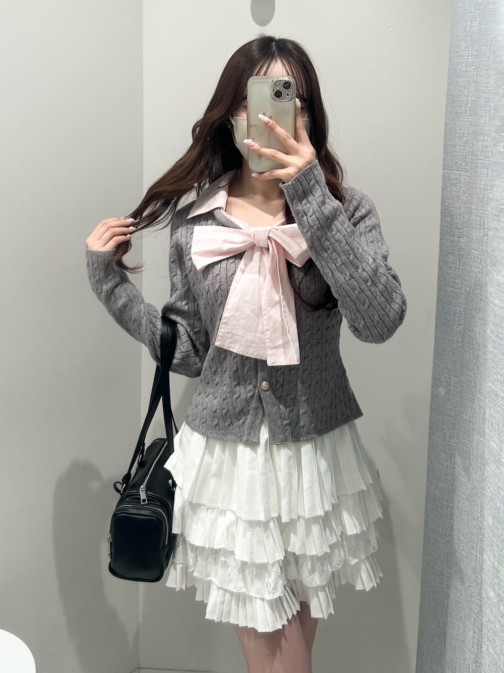 ブラック系のトートバッグ、ホワイト系のスカート、グレー系のニット/セーターを着用したレディースの冬コーディネートの6枚目の写真