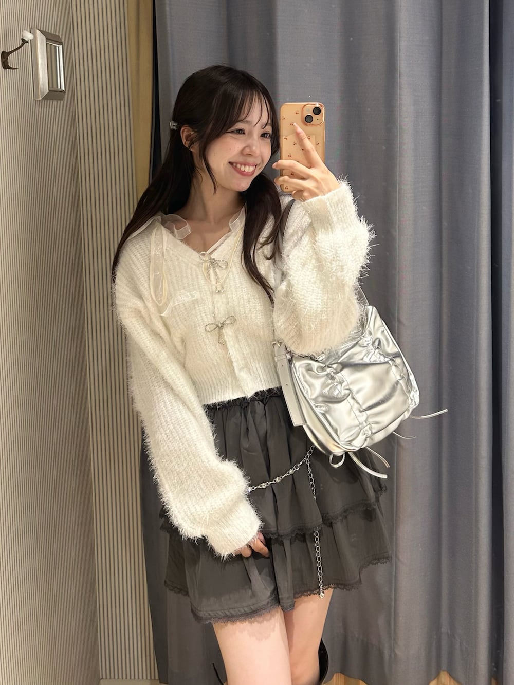 ホワイト系のカーディガン/ボレロ、ホワイト系のキャミソール、シルバー系のショルダーバッグを着用したレディースの秋コーディネートの4枚目の写真