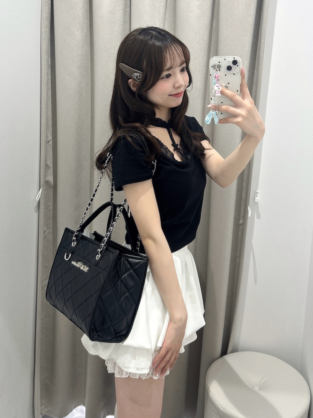 ブラック系のトートバッグ、ホワイト系のスカート、ブラック系のTシャツ/カットソーを着用したレディースの春コーディネートの2枚目の写真