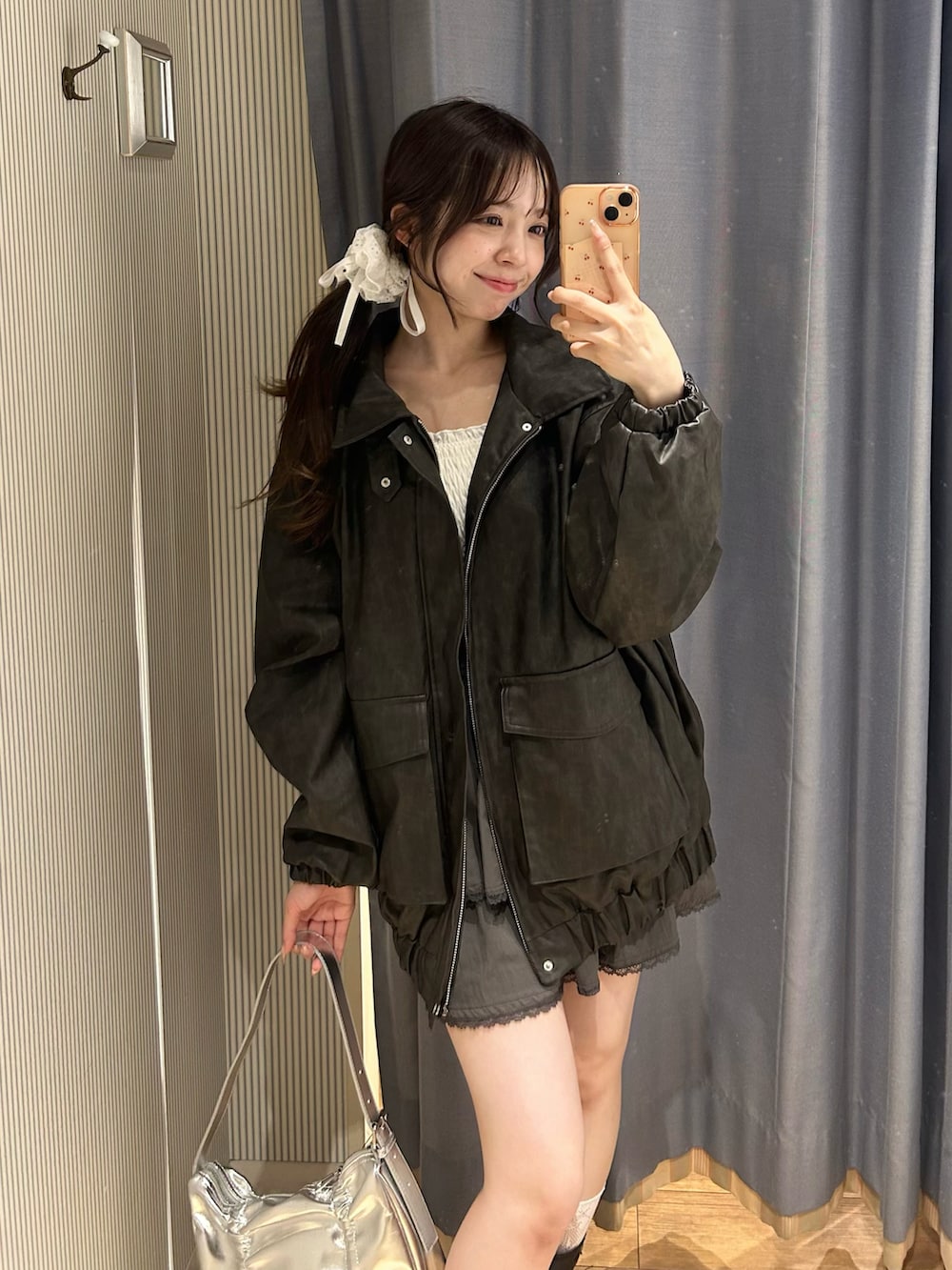 ホワイト系のキャミソール、ブラック系のブルゾン、グレー系のスカートを着用したレディースの秋コーディネートの3枚目の写真