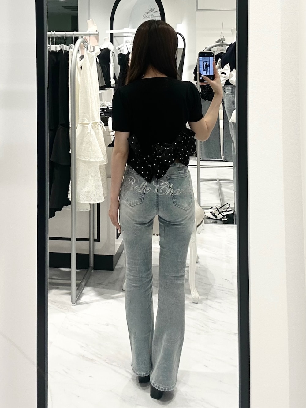 ブラック系のカーディガン/ボレロ、ブルー系のデニムパンツを着用したレディースの春コーディネートの2枚目の写真