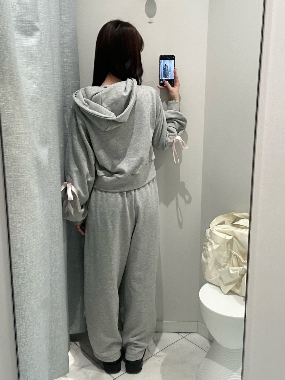 グレー系のスウェットパンツ、グレー系のパーカー、イエロー系のボストンバッグを着用したレディースの冬コーディネートの4枚目の写真