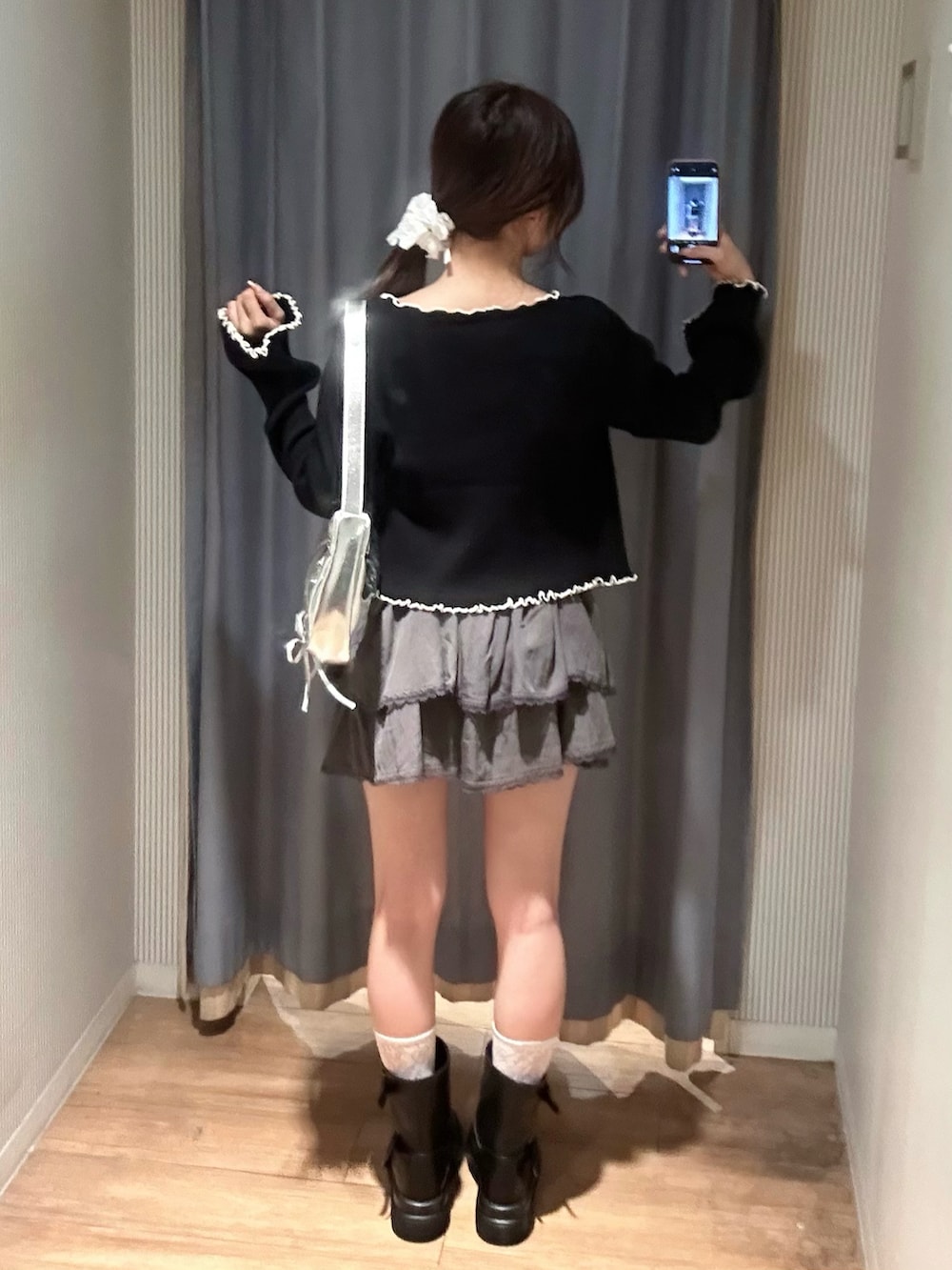 グレー系のスカート、ホワイト系のキャミソール、ブラック系のカーディガン/ボレロを着用したレディースの秋コーディネートの5枚目の写真