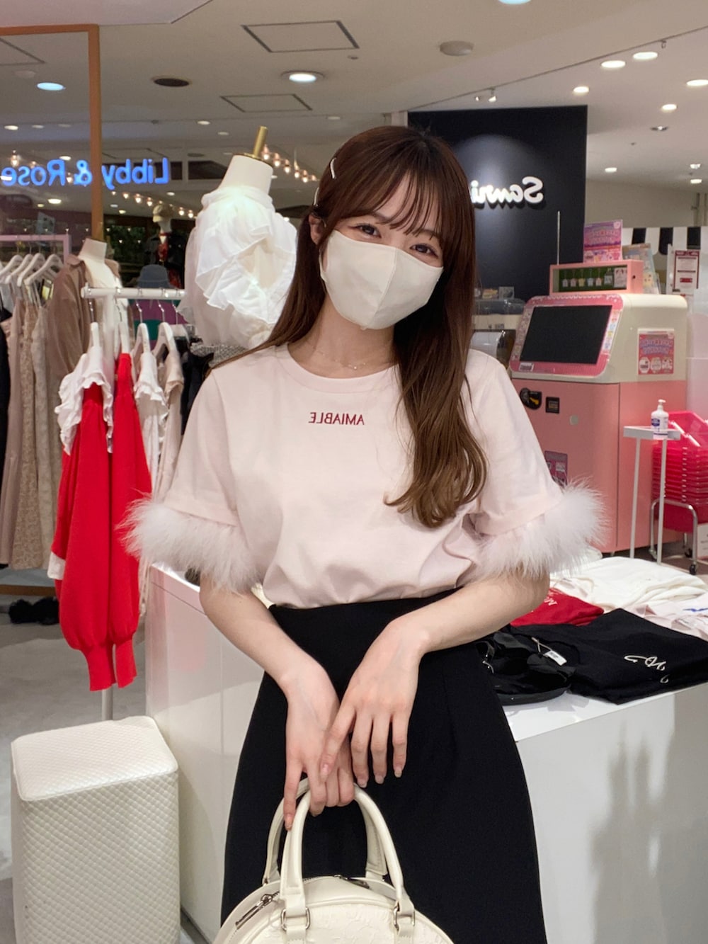 ピンク系のTシャツ/カットソー、ブラック系のスカート、ホワイト系のボストンバッグを着用したレディースの春コーディネートの4枚目の写真