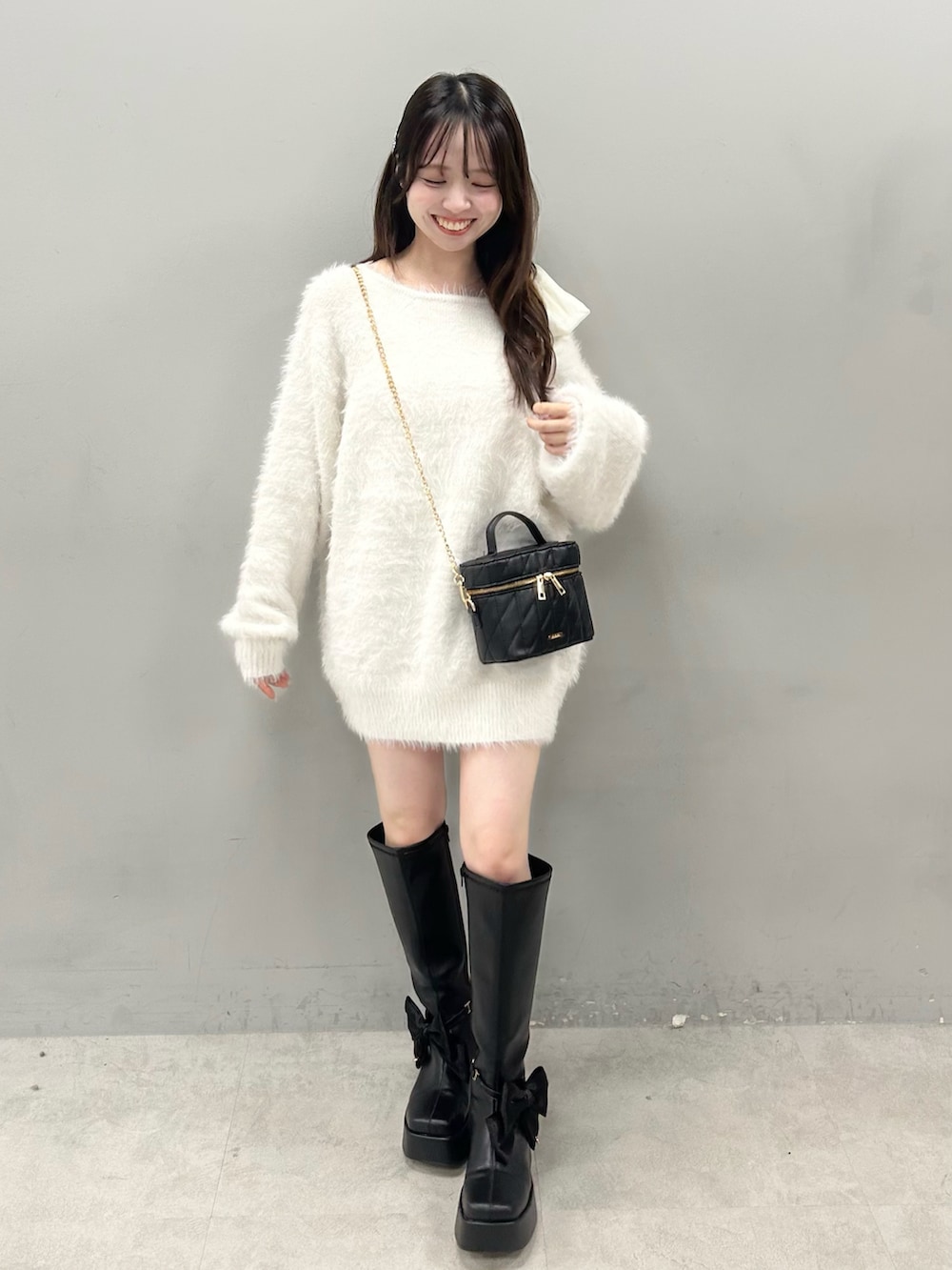 ブラック系のブーツ、ホワイト系のワンピースを着用したレディースの夏コーディネートの3枚目の写真