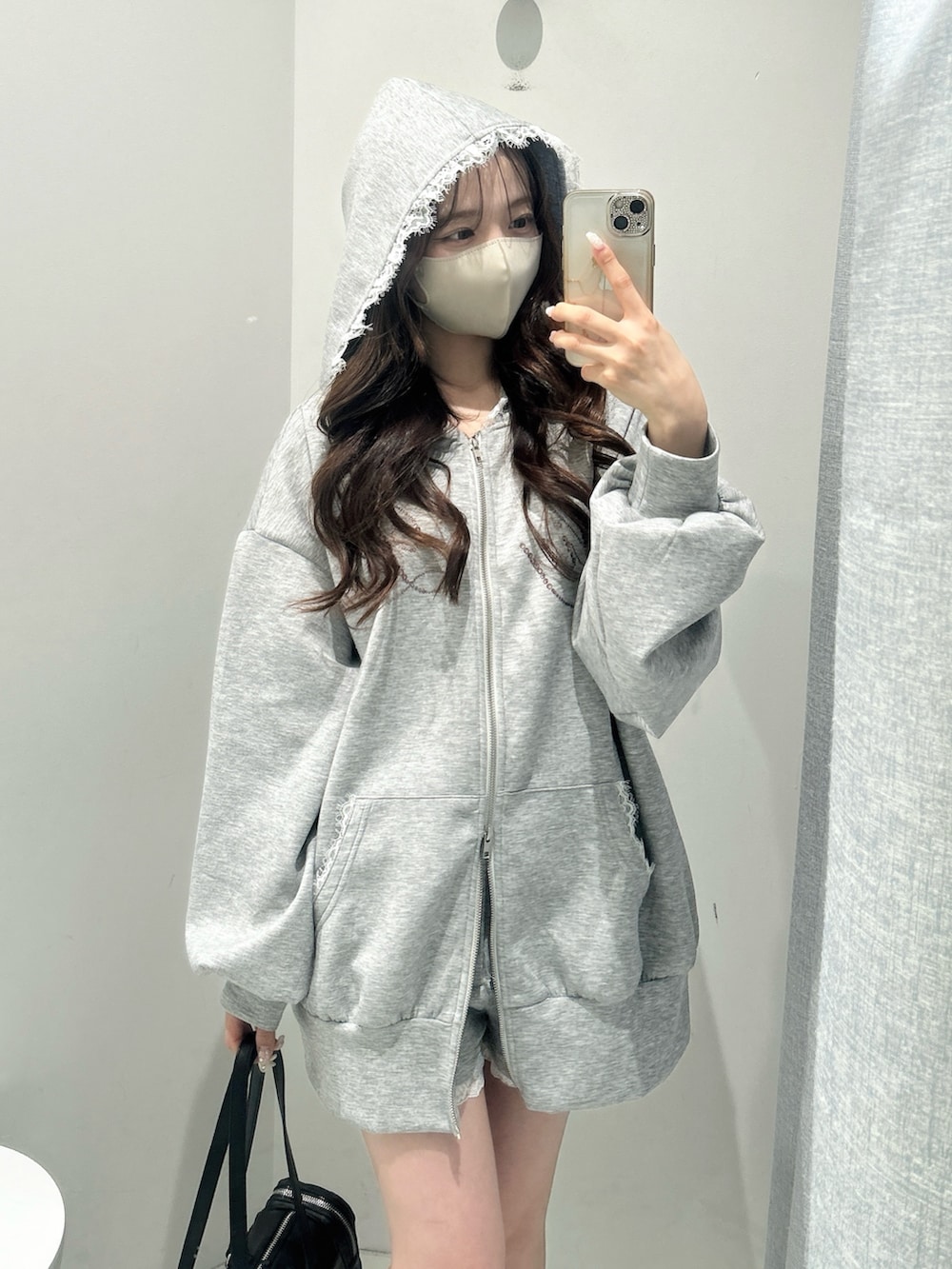 グレー系のパーカー、グレー系のその他パンツ、ブラック系のトートバッグを着用したレディースの冬コーディネートの3枚目の写真