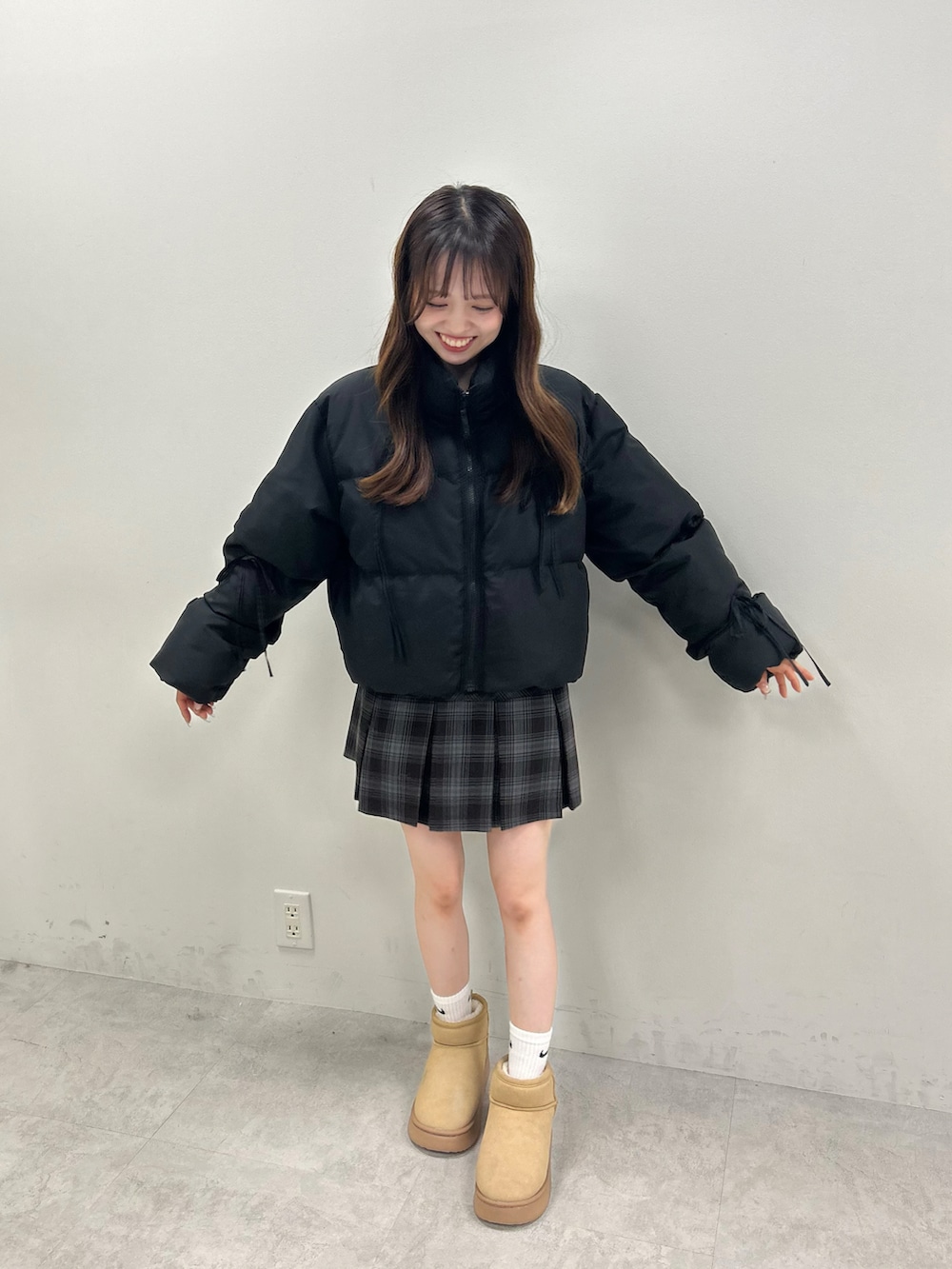 ブラック系のダウンジャケット/コート、グレー系のスカート、ベージュ系のブーツを着用したレディースの秋コーディネートの3枚目の写真