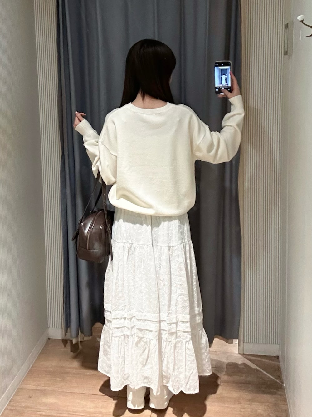 ピンク系のニット/セーター、ホワイト系のスカート、ホワイト系のショルダーバッグを着用したレディースの冬コーディネートの5枚目の写真