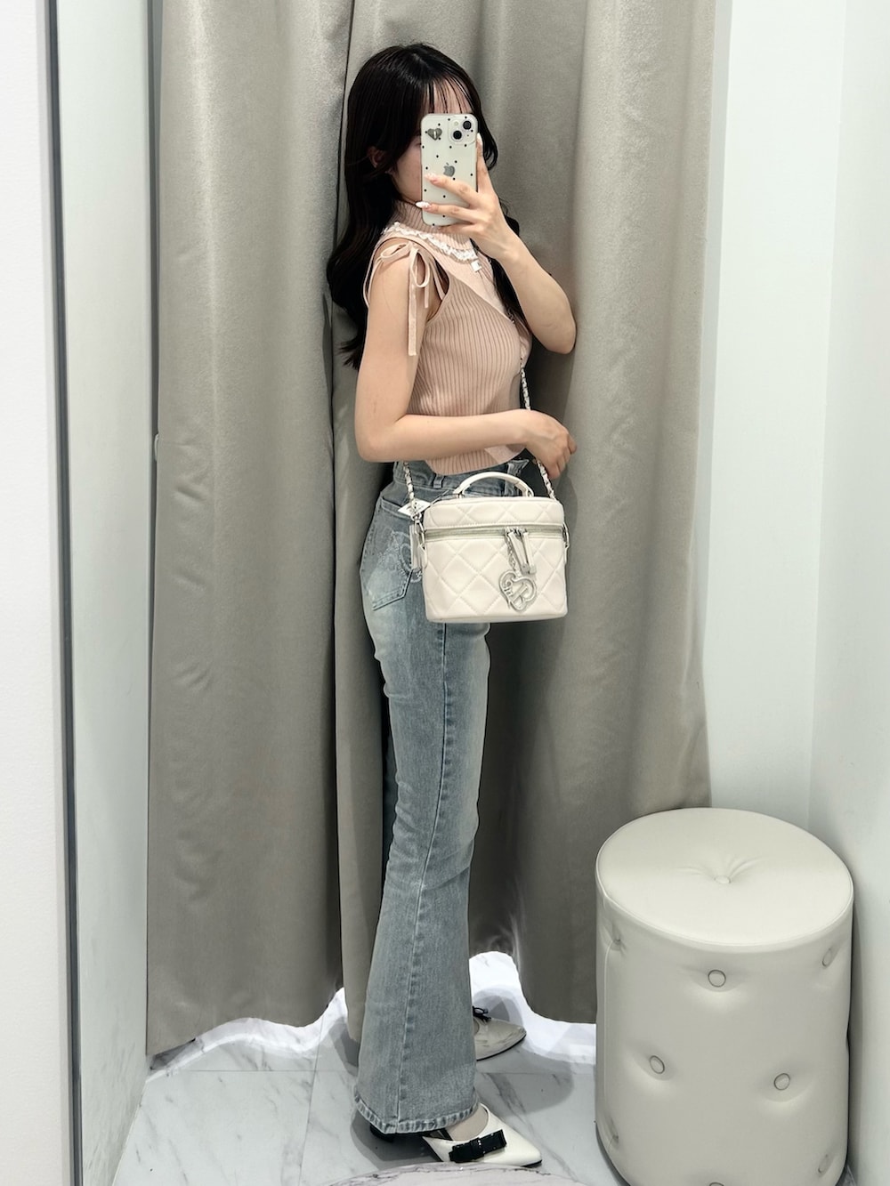 ピンク系のアンサンブル、ホワイト系のショルダーバッグ、ブルー系のデニムパンツを着用したレディースの夏コーディネートの2枚目の写真
