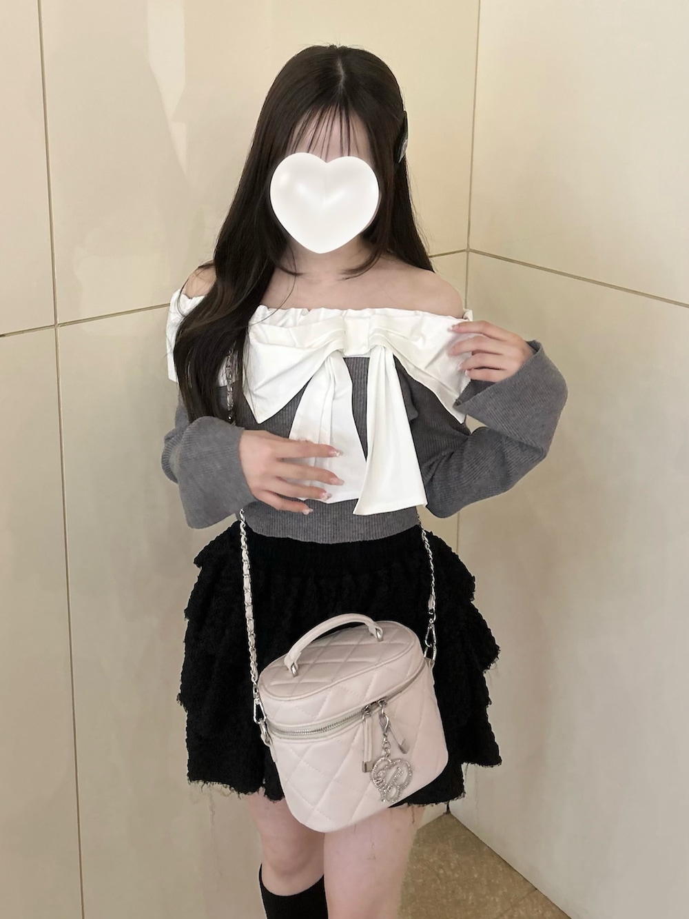 グレー系のニット/セーター、ホワイト系のショルダーバッグ、ブラック系のスカートを着用したレディースの冬コーディネートの6枚目の写真