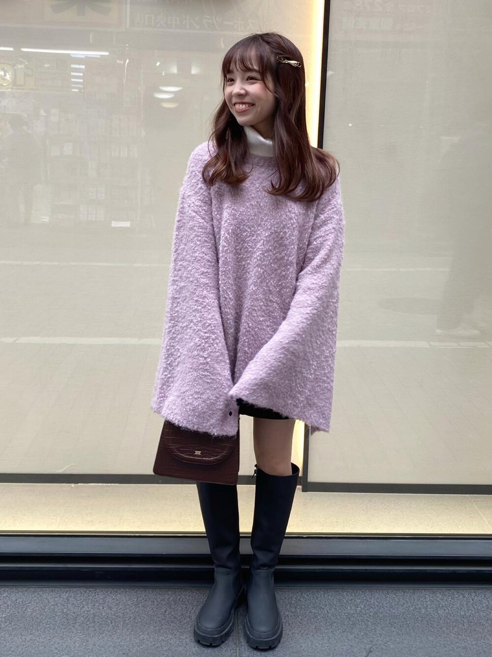 ピンク系のニット/セーター、ブラック系のその他パンツ、ブラック系のブーツを着用したレディースの秋コーディネートの2枚目の写真