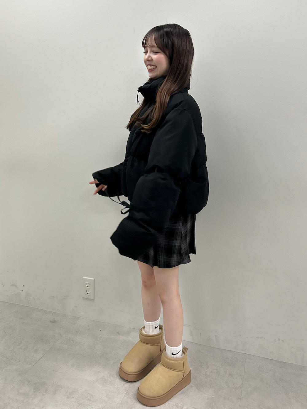 ブラック系のダウンジャケット/コート、グレー系のスカート、ベージュ系のブーツを着用したレディースの秋コーディネートの4枚目の写真