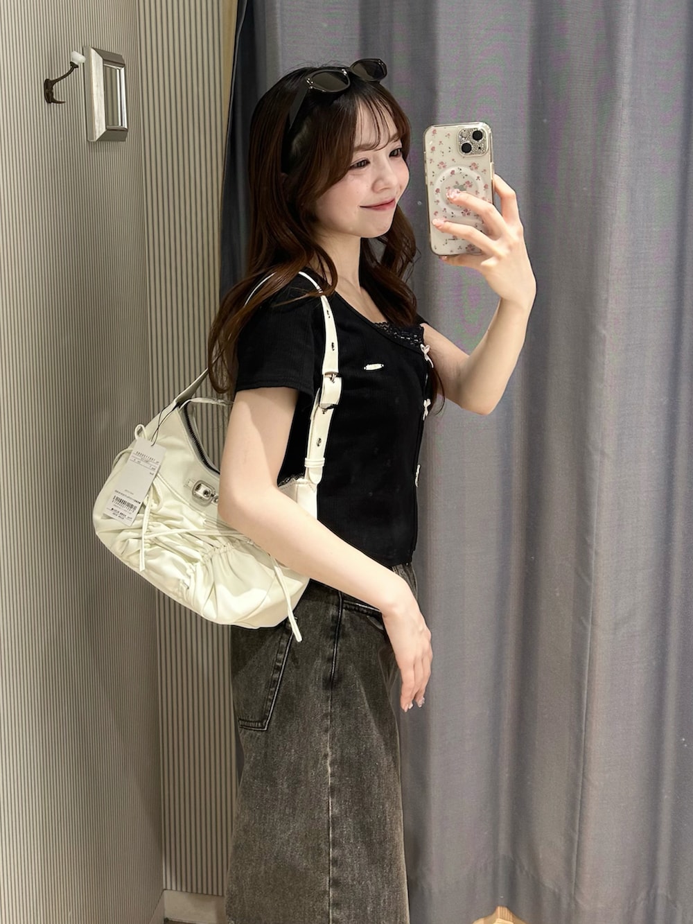 ブラック系のTシャツ/カットソー、ブラック系のデニムパンツ、ホワイト系のショルダーバッグを着用したレディースの春コーディネートの2枚目の写真