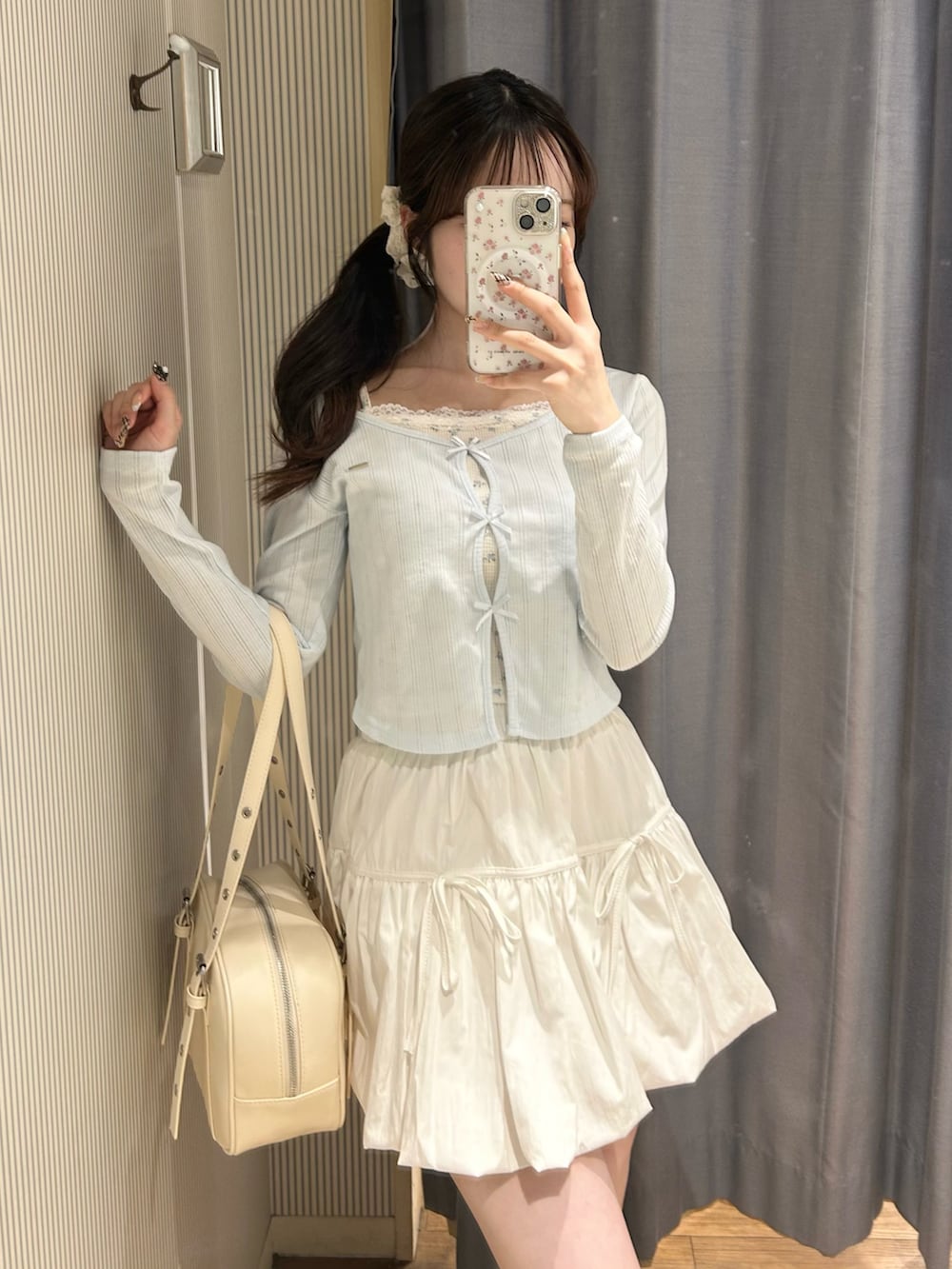 ホワイト系のショルダーバッグ、ホワイト系のスカート、ブルー系のTシャツ/カットソーを着用したレディースの春コーディネートの2枚目の写真