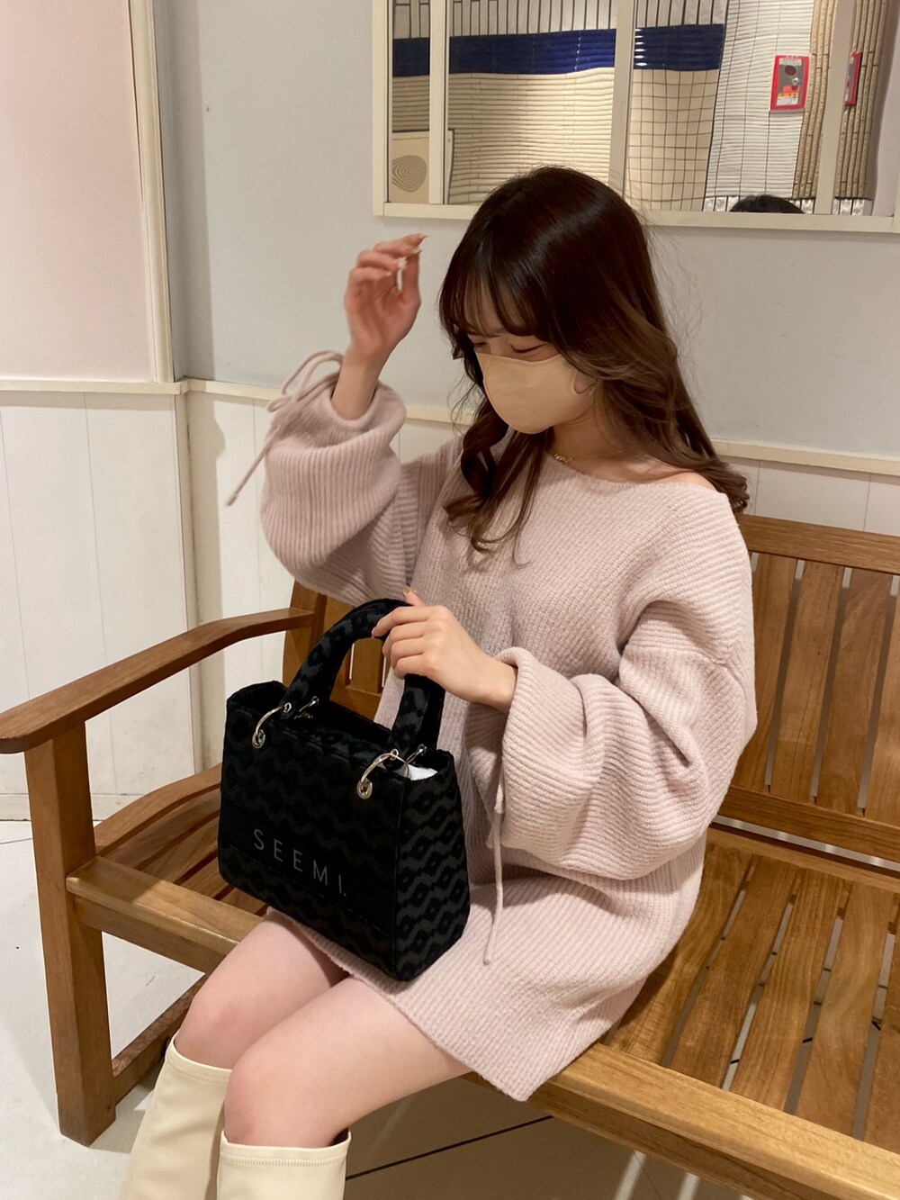 ホワイト系のブーツ、ピンク系のワンピース、ブラック系のショルダーバッグを着用したレディースの冬コーディネートの3枚目の写真