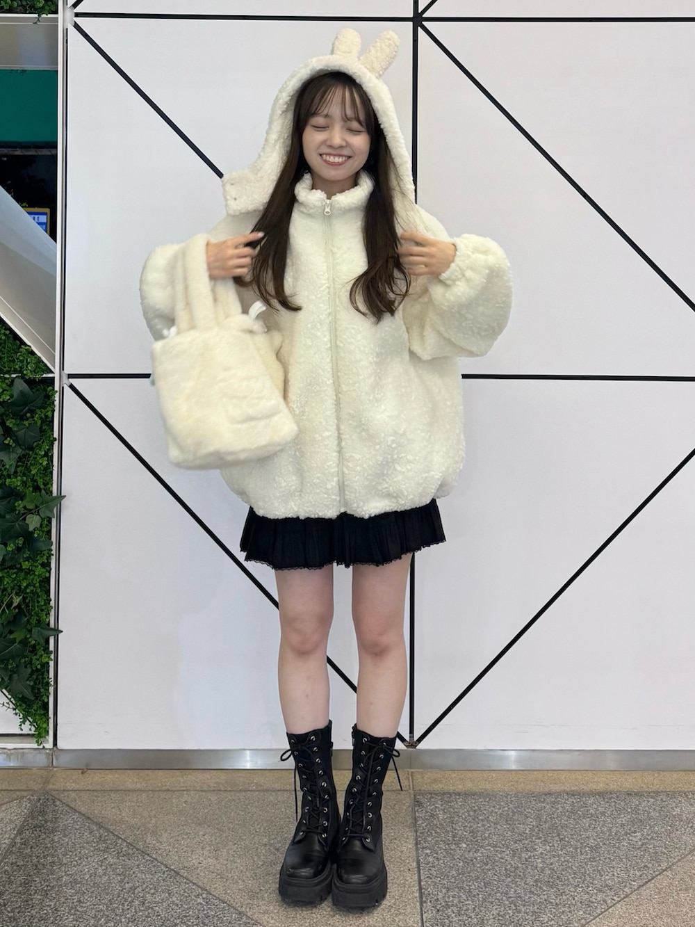 ホワイト系のジャケット/アウター、ホワイト系のバッグ、ブラック系のスカートを着用したレディースの冬コーディネートの5枚目の写真