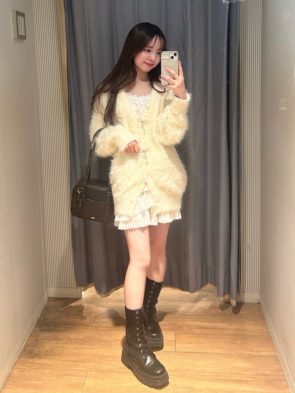 ブラウン系のショルダーバッグ、ホワイト系のワンピース、ホワイト系のカーディガン/ボレロを着用したレディースの冬コーディネートの3枚目の写真