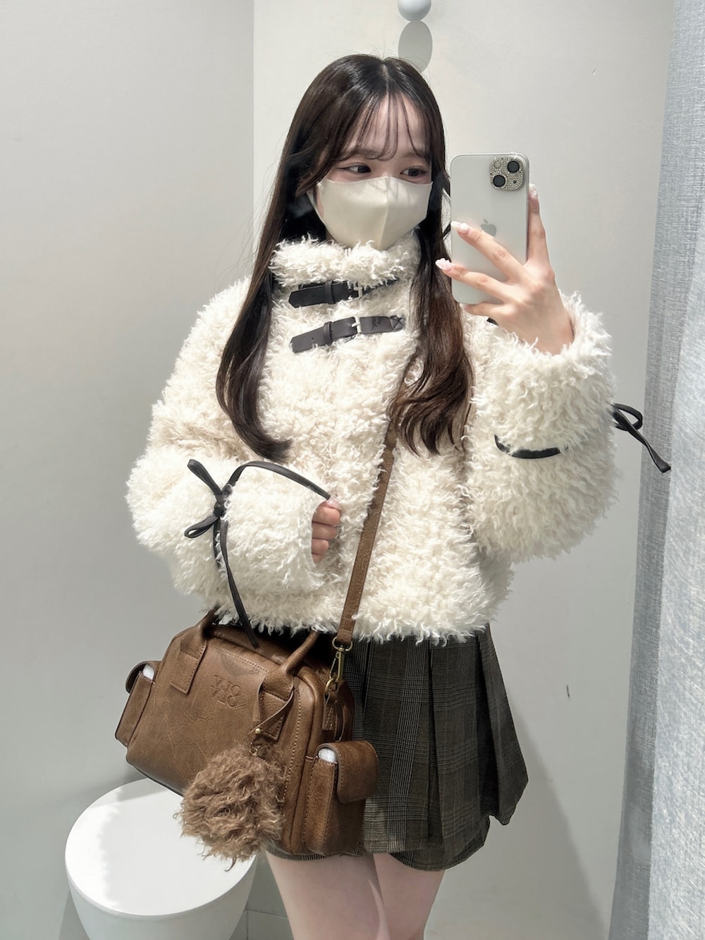 ブラウン系のブーツ、ブラウン系のショルダーバッグ、ブラウン系のスカートを着用したレディースの秋コーディネートの5枚目の写真