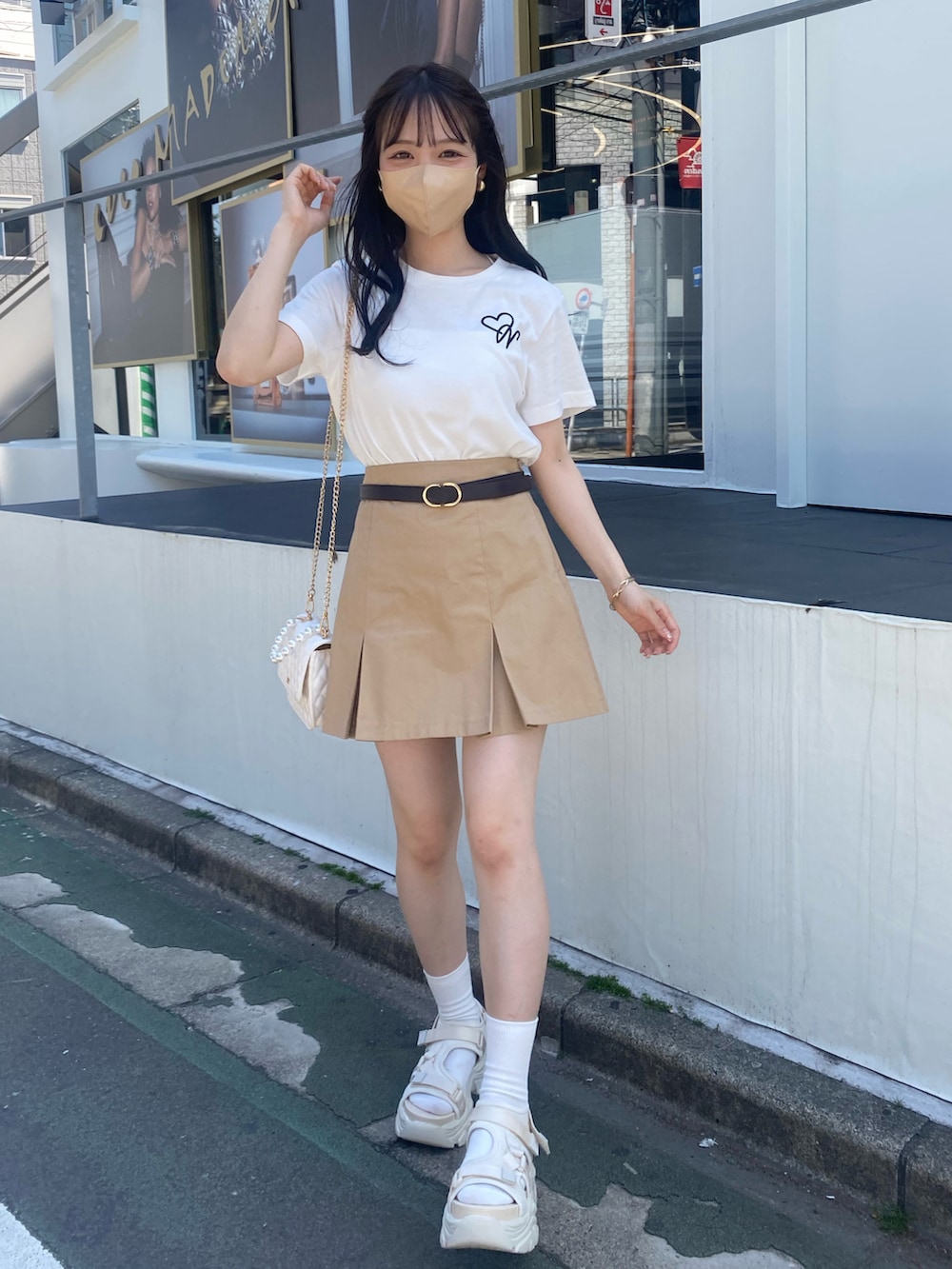 ホワイト系のTシャツ/カットソー、ホワイト系のサンダル、ベージュ系のスカートを着用したレディースの夏コーディネートの3枚目の写真