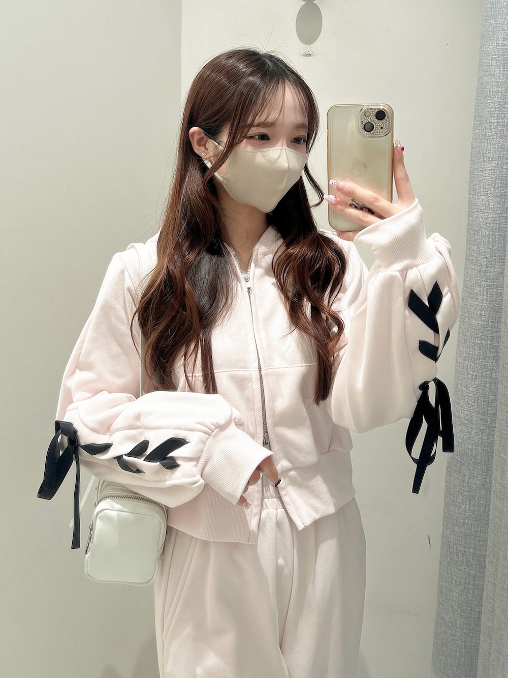 ホワイト系のスニーカー、ピンク系のスウェットパンツ、ピンク系のパーカーを着用したレディースの冬コーディネートの6枚目の写真