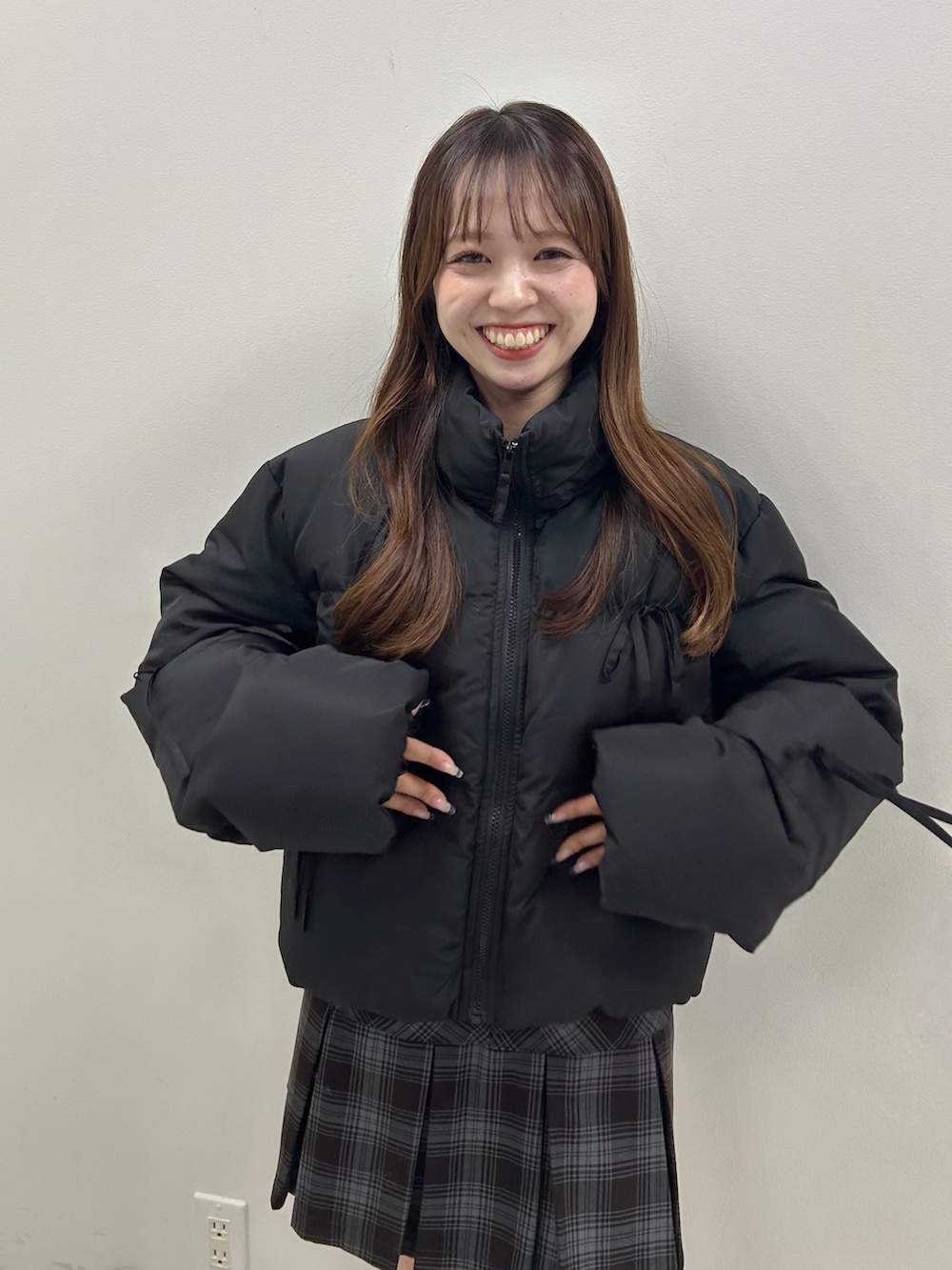 ブラック系のダウンジャケット/コート、グレー系のスカート、ベージュ系のブーツを着用したレディースの秋コーディネートの5枚目の写真