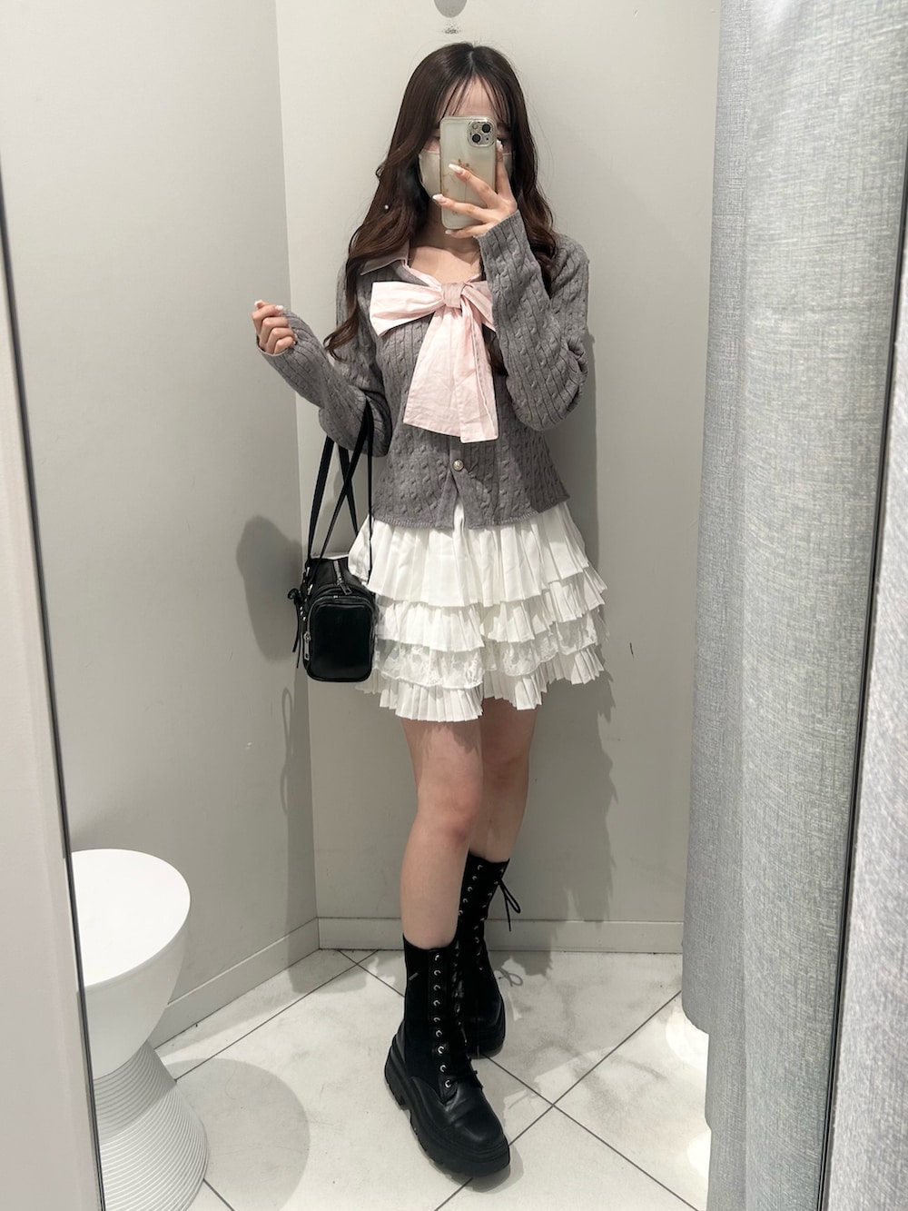 ブラック系のトートバッグ、ホワイト系のスカート、グレー系のニット/セーターを着用したレディースの冬コーディネートの3枚目の写真