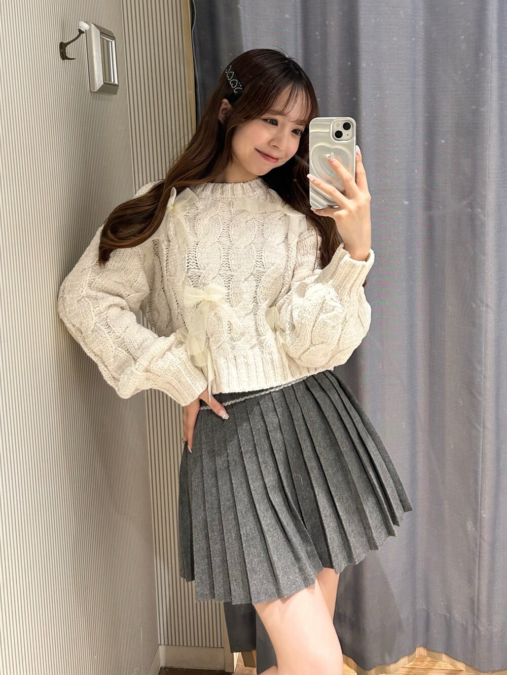 グレー系のスカート、ホワイト系のニット/セーターを着用したレディースの秋コーディネートの3枚目の写真