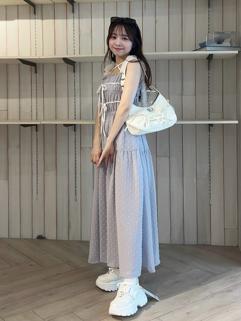 ホワイト系のショルダーバッグ、ブルー系のワンピース、ホワイト系のシューズを着用したレディースの春コーディネートの3枚目の写真