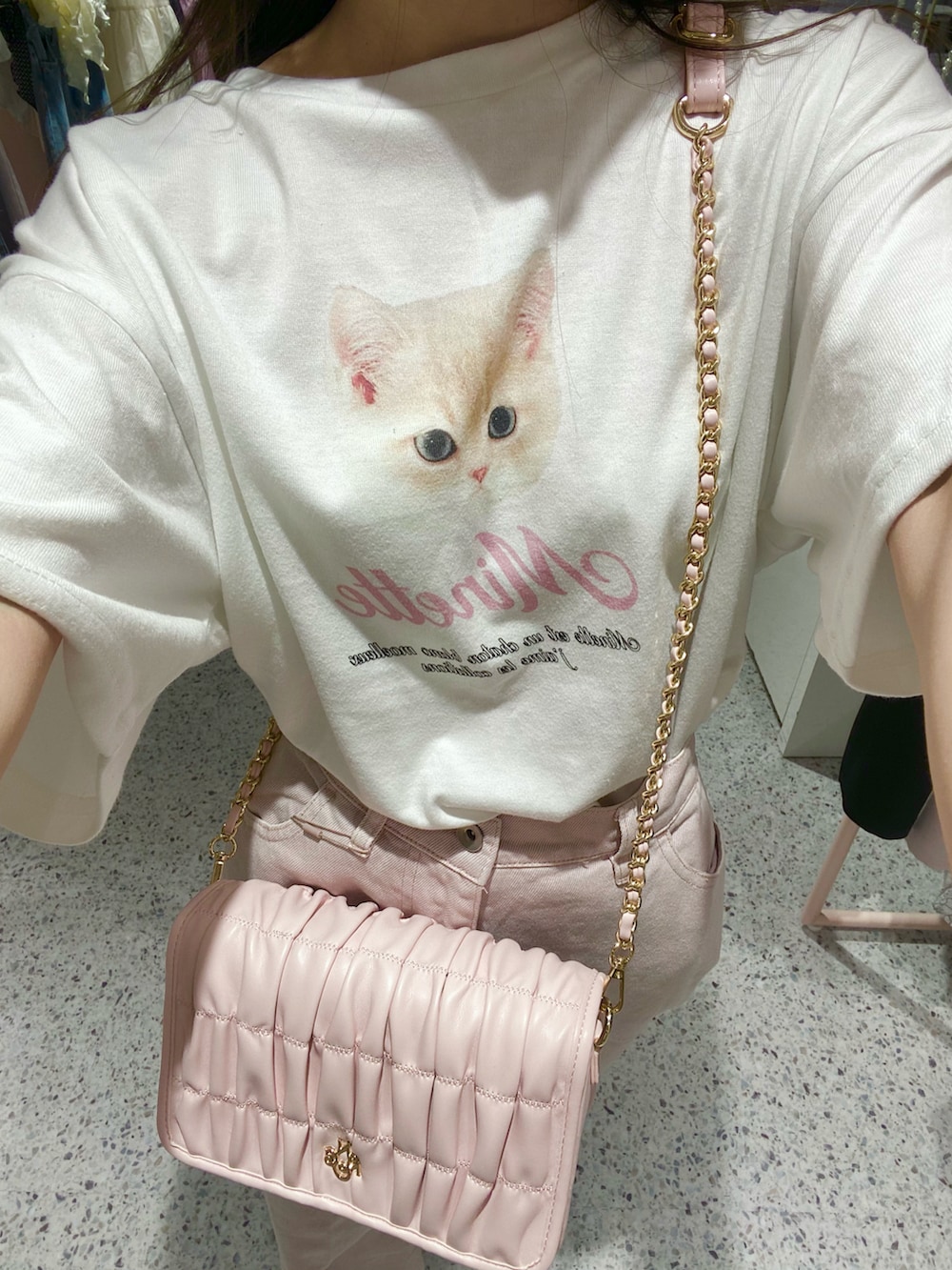 ホワイト系のスニーカー、ピンク系のデニムパンツ、ピンク系のショルダーバッグを着用したレディースの夏コーディネートの4枚目の写真