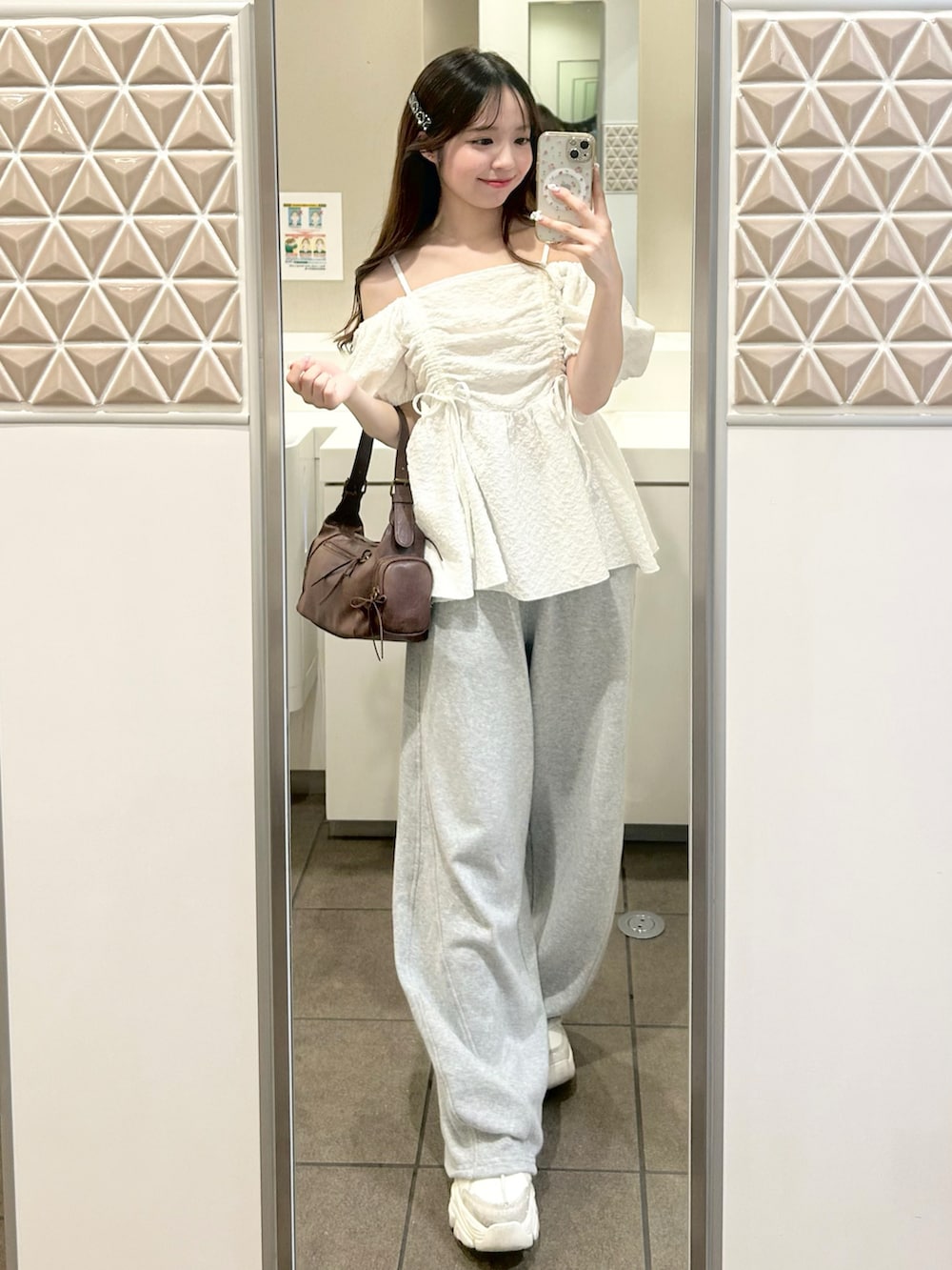 グレー系のスウェットパンツ、ホワイト系のシャツ/ブラウス、ブラウン系のショルダーバッグを着用したレディースの夏コーディネートの2枚目の写真