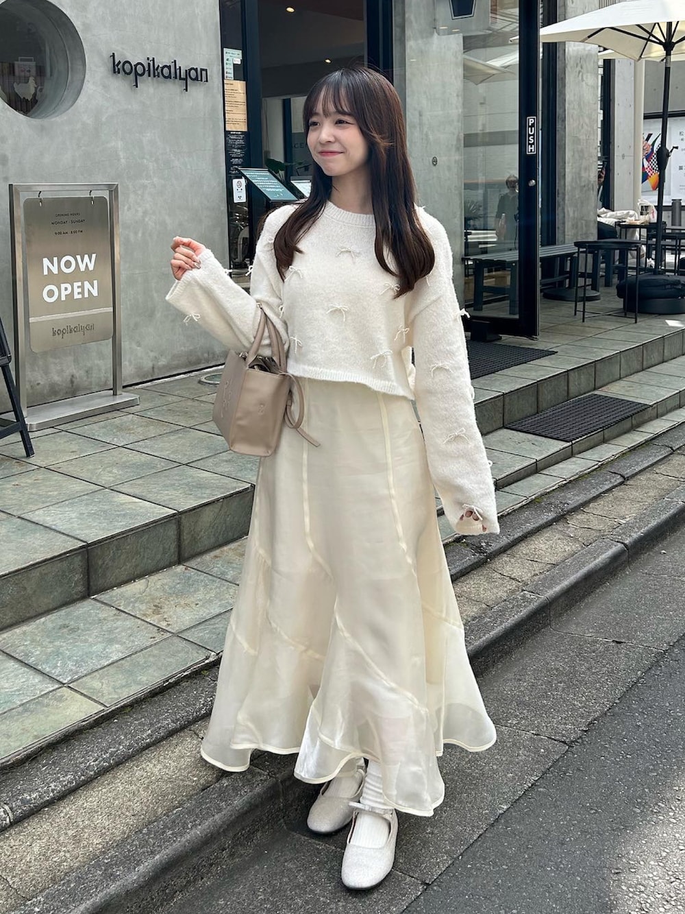 ホワイト系のスカート、ホワイト系のバレエシューズ、ホワイト系のニット/セーターを着用したレディースの秋コーディネートの3枚目の写真