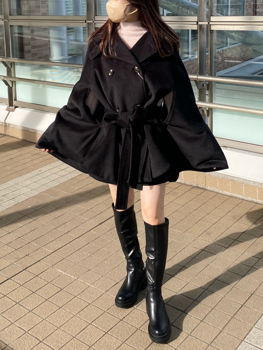 ブラック系のブーツ、ブラック系のポンチョ、ピンク系のニット/セーターを着用したレディースの冬コーディネートの4枚目の写真