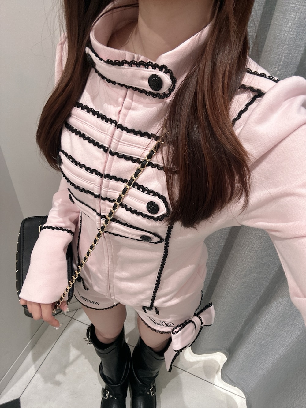 ブラック系のブーツ、ピンク系のその他アウター、ブラック系のショルダーバッグを着用したレディースの秋コーディネートの9枚目の写真