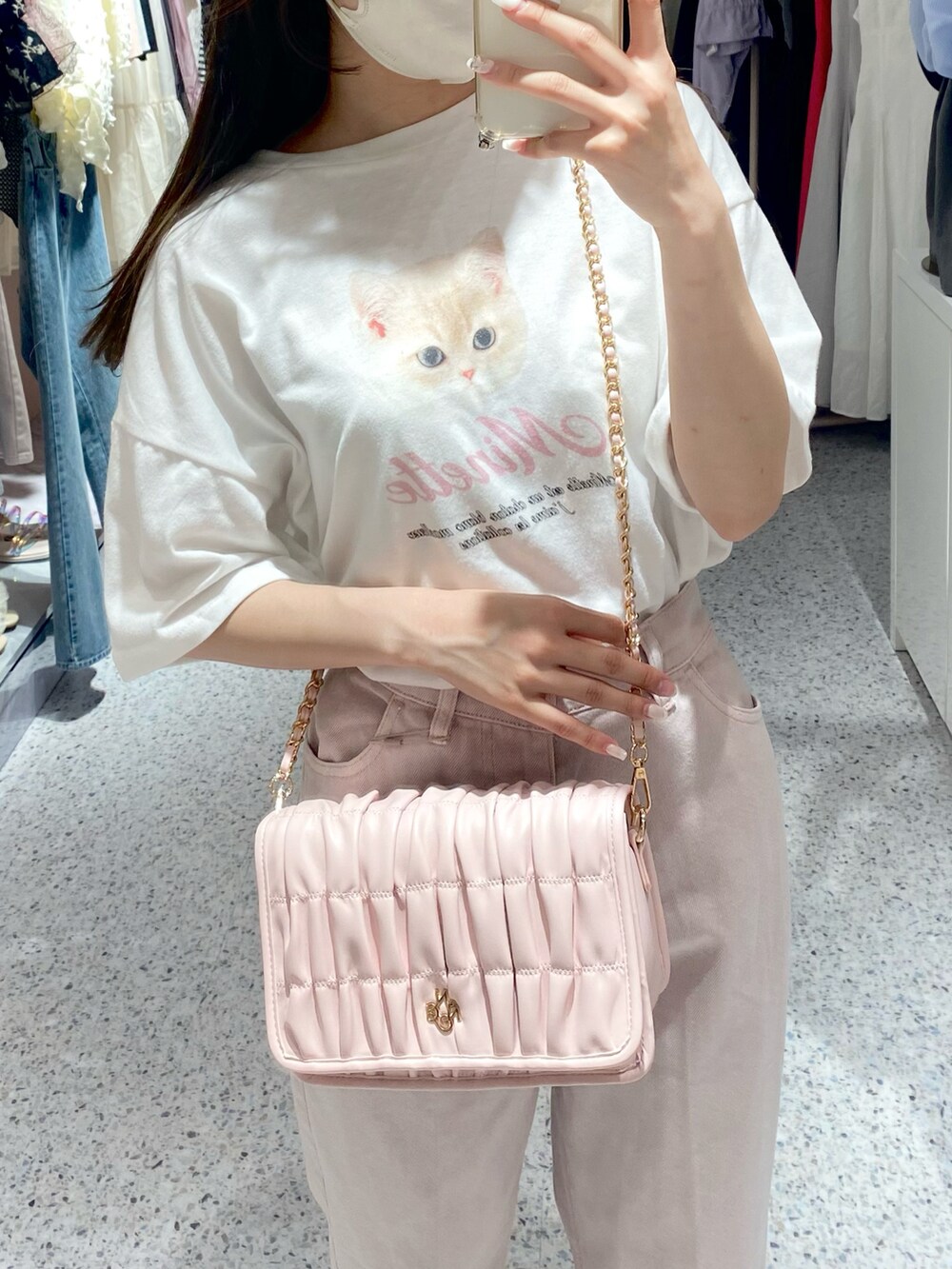 ホワイト系のスニーカー、ピンク系のデニムパンツ、ピンク系のショルダーバッグを着用したレディースの夏コーディネートの3枚目の写真