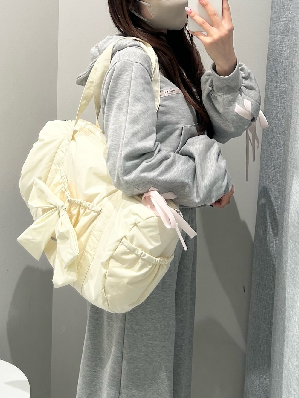 グレー系のスウェットパンツ、グレー系のパーカー、イエロー系のボストンバッグを着用したレディースの冬コーディネートの5枚目の写真