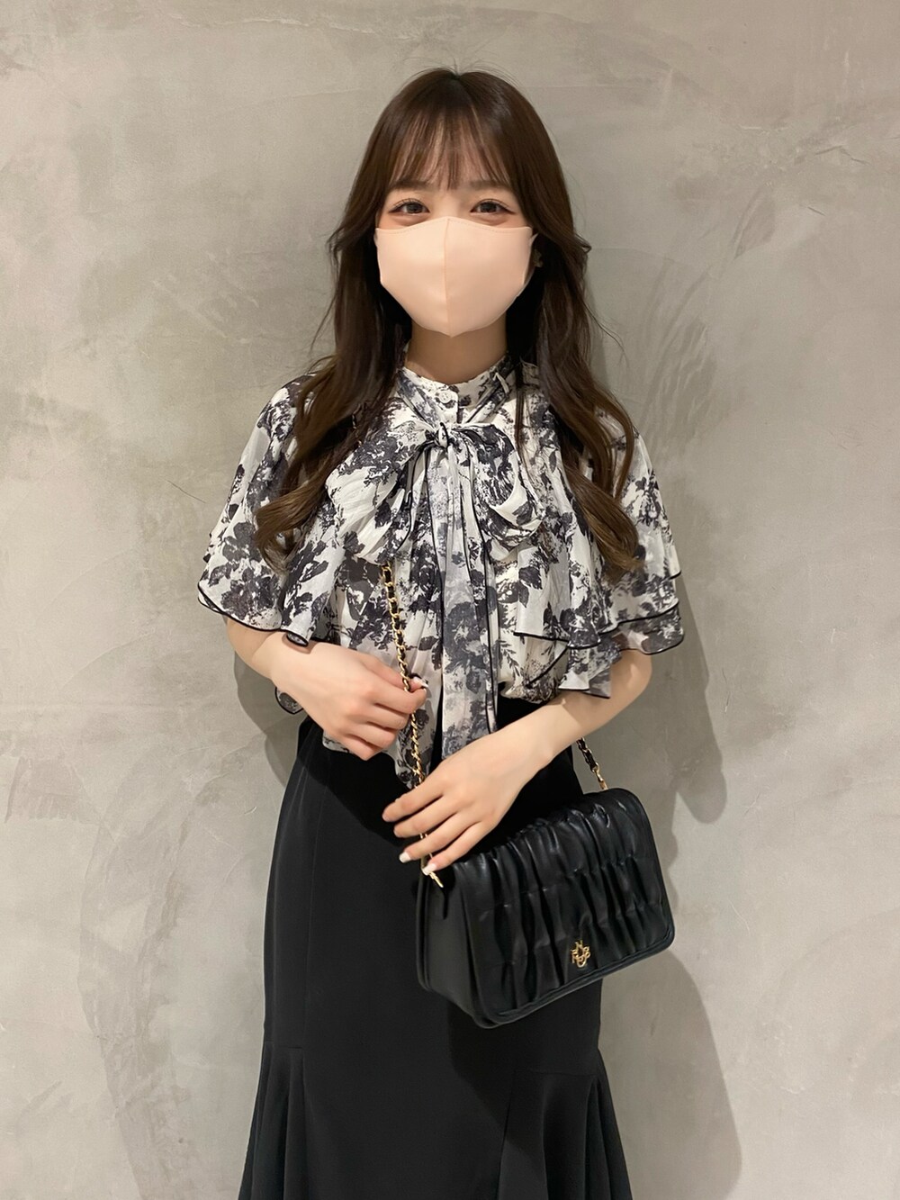 ホワイト系のシャツ/ブラウス、ブラック系のスカート、ホワイト系のショルダーバッグを着用したレディースの夏コーディネートの3枚目の写真