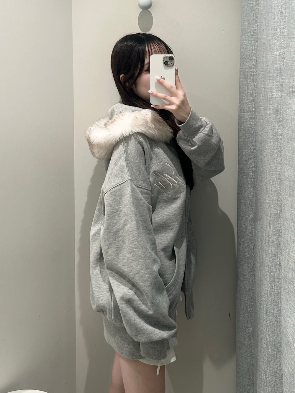 グレー系のパーカー、ホワイト系のスカートを着用したレディースの秋コーディネートの4枚目の写真