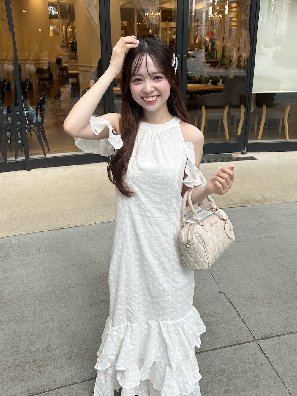 ホワイト系のワンピース、ベージュ系のボストンバッグ、ホワイト系のサンダルを着用したレディースの夏コーディネートの4枚目の写真