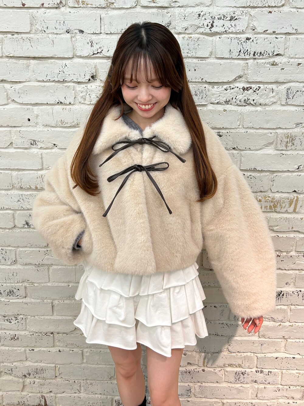 ベージュ系のブルゾン、ホワイト系のスカート、ブラック系のブーツを着用したレディースの秋コーディネートの3枚目の写真