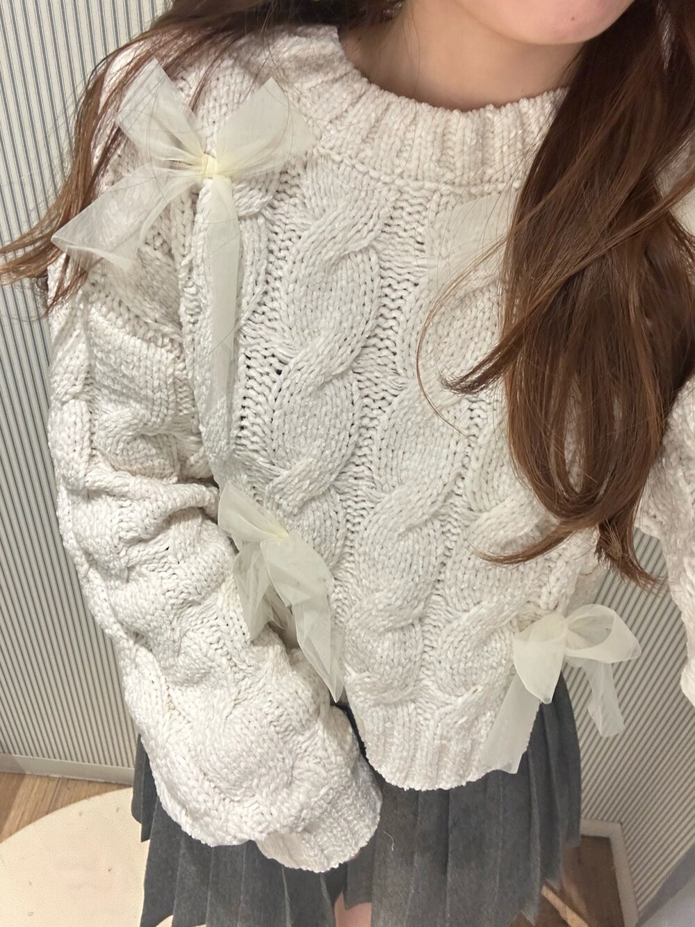 グレー系のスカート、ホワイト系のニット/セーターを着用したレディースの秋コーディネートの5枚目の写真